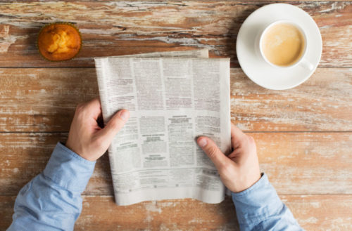 Close up of male hands with newspaper