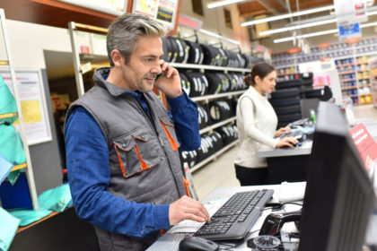 Mechanic in car repair shop talking on phone