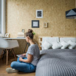 Student woman sitting on the floor in her bedroom