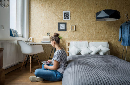 Student woman sitting on the floor in her bedroom